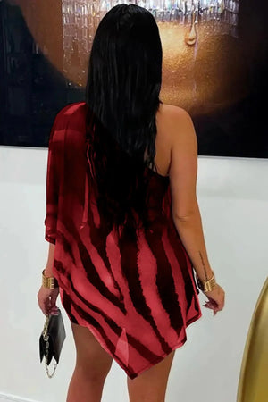 Woman wearing a red and black patterned dress with a blurred background